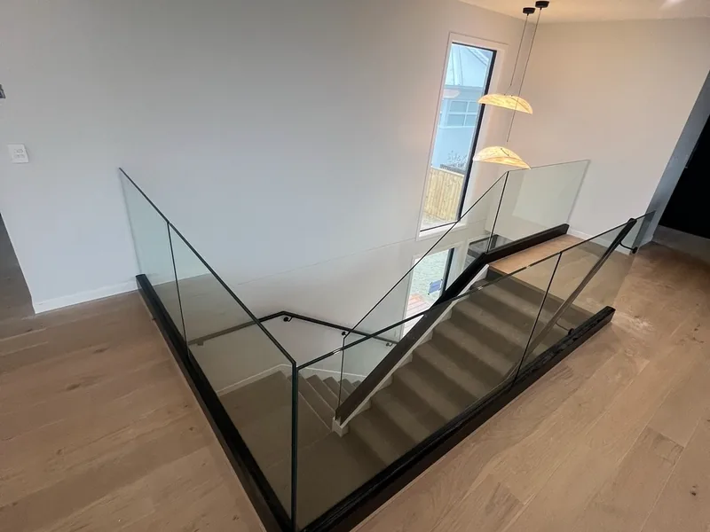 Glass balustrade around an upstairs landing with a timber floor